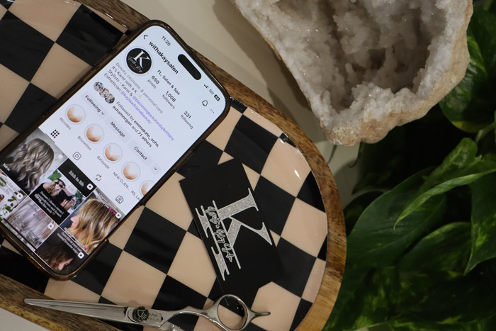 With a Kay Salon open on a phone with a business card next to it